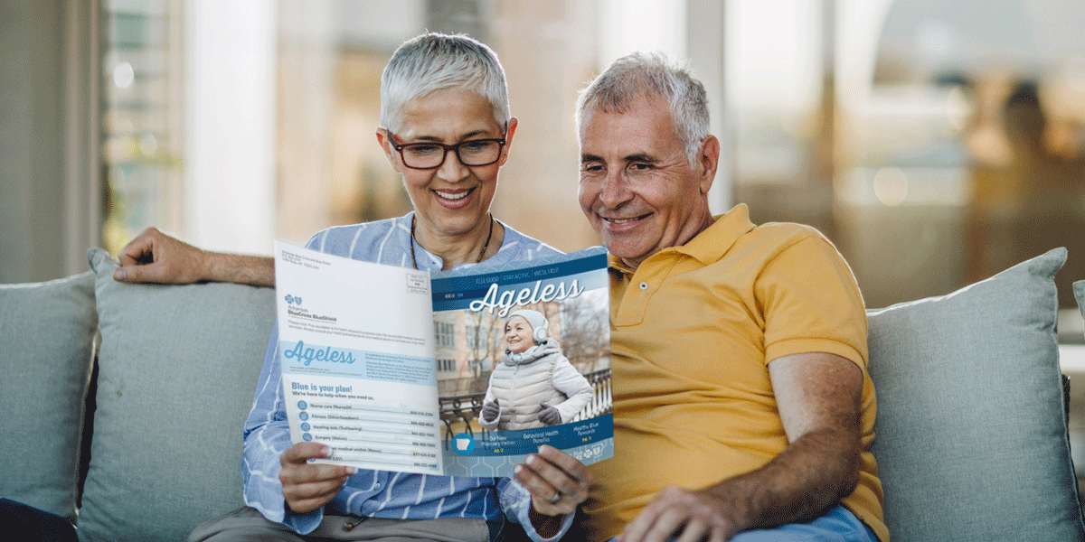 Couple reading Ageless Magazine on couch