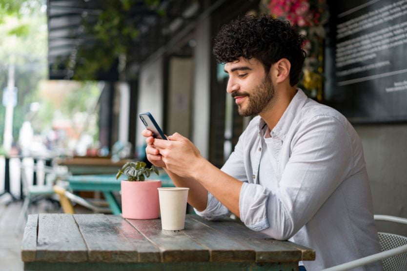 Man sitting at a table looking at his cell phone