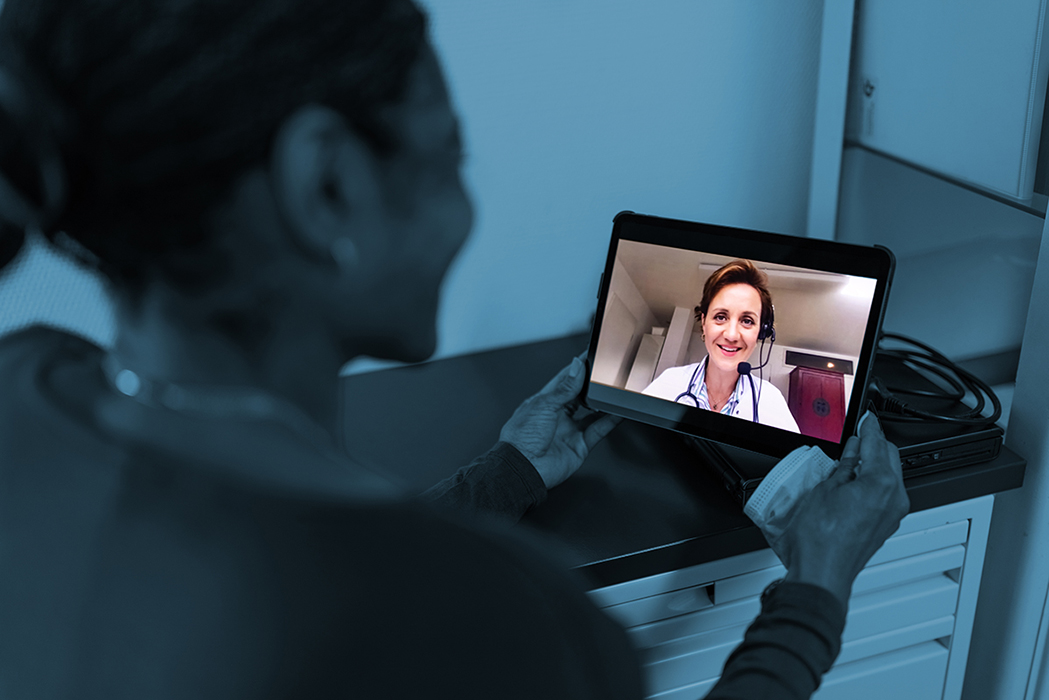 Woman holding iPad with a doctor on it.